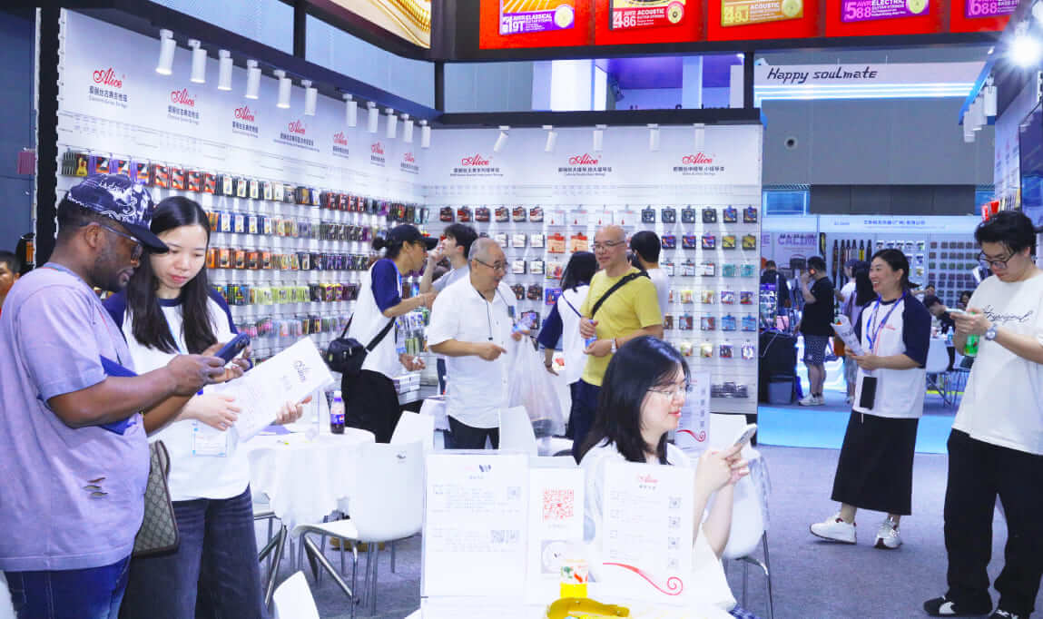 Visitors and buyers browsing the extensive Alice guitar strings and accessories display wall